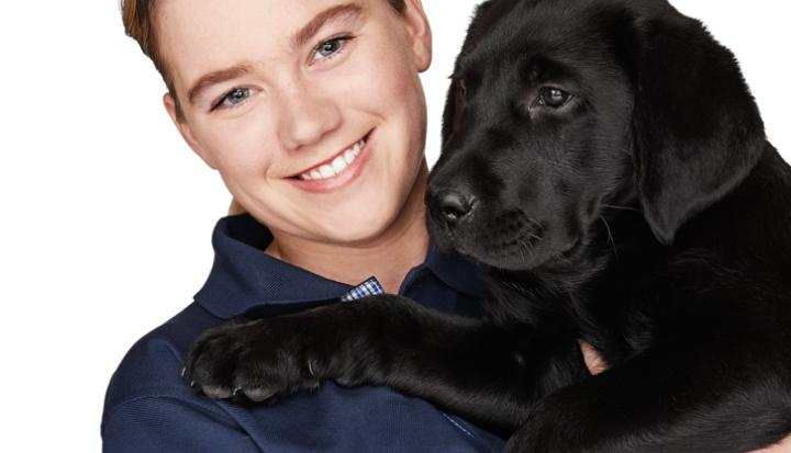 Staff member holding a seeing eye dog puppy